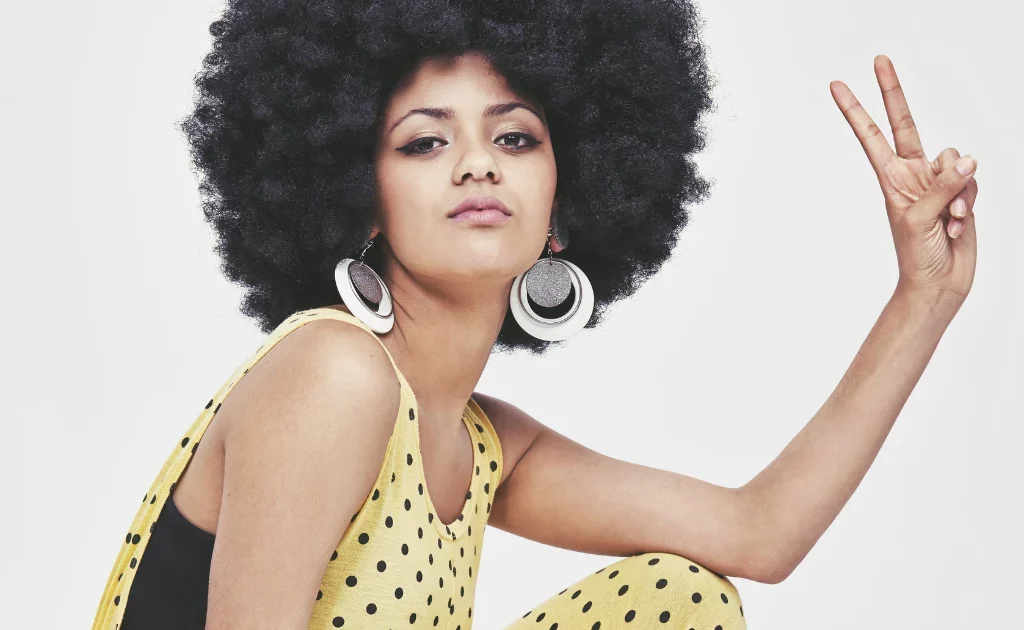 Femme avec coupe afro vintage incarnant les coupes inspirées des années 70 à Paris