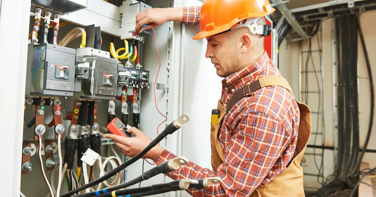 Électricien auto-entrepreneur travaillant sur un tableau électrique