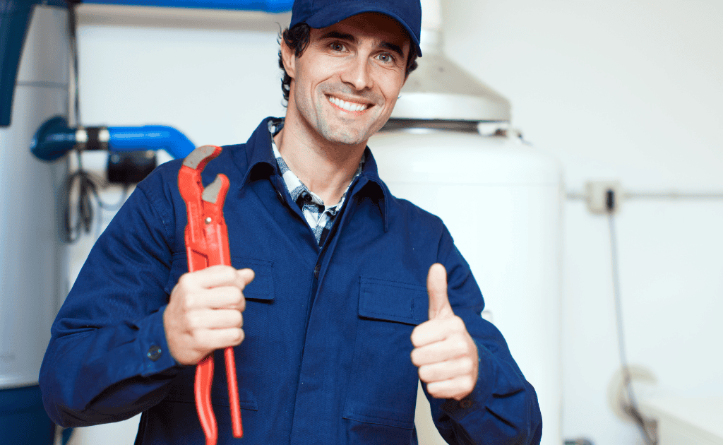 Plombier souriant en tenue professionnelle levant le pouce, prêt pour une intervention rapide et fiable.