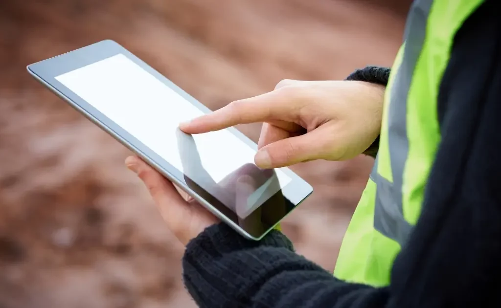 Artisan BTP utilisant une tablette robuste sur un chantier pour gérer son activité