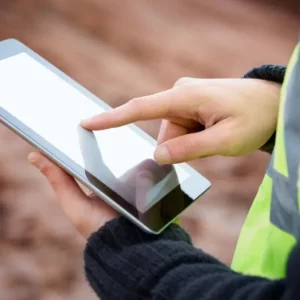 Artisan BTP utilisant une tablette robuste sur un chantier pour gérer son activité