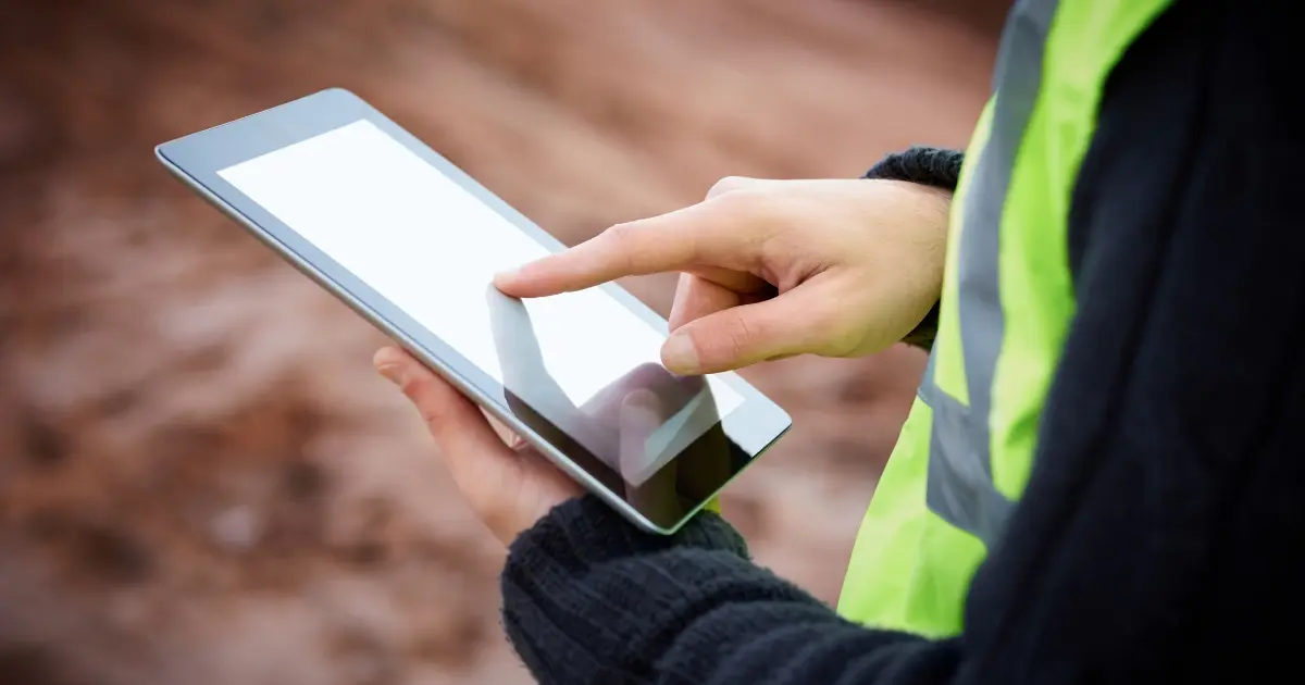 Artisan BTP utilisant une tablette robuste sur un chantier pour gérer son activité