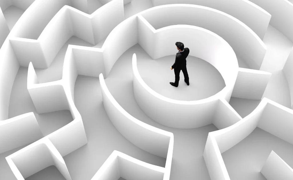 Un homme au centre d’un labyrinthe complexe, symbolisant les défis et obstacles auxquels les freelances font face dans leur parcours professionnel. défis des freelances et indépendants