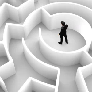 Un homme au centre d’un labyrinthe complexe, symbolisant les défis et obstacles auxquels les freelances font face dans leur parcours professionnel. défis des freelances et indépendants