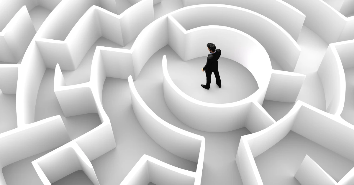 Un homme au centre d’un labyrinthe complexe, symbolisant les défis et obstacles auxquels les freelances font face dans leur parcours professionnel. défis des freelances et indépendants