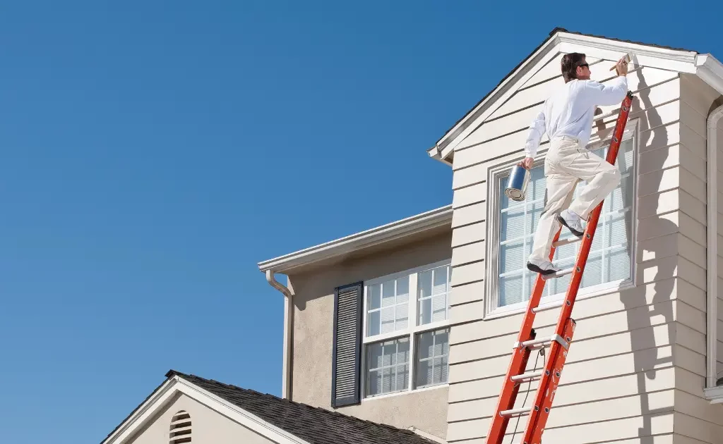 peintre auto-entrepreneur réalisant des travaux de peinture dans une résidence secondaire lumineuse