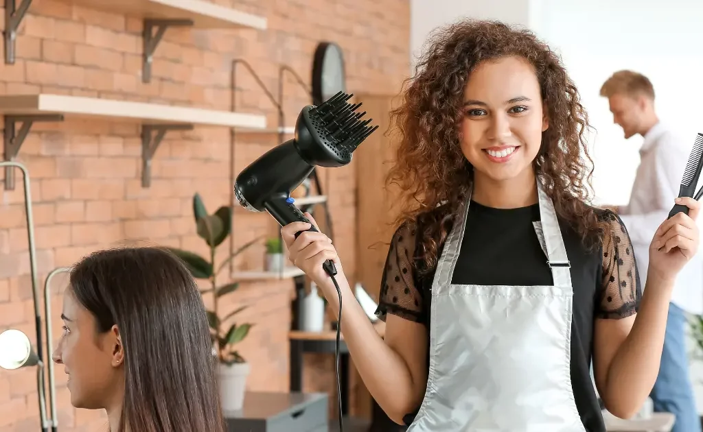 Jeune coiffeuse parisienne regardant l'objectif dans un salon de coiffure